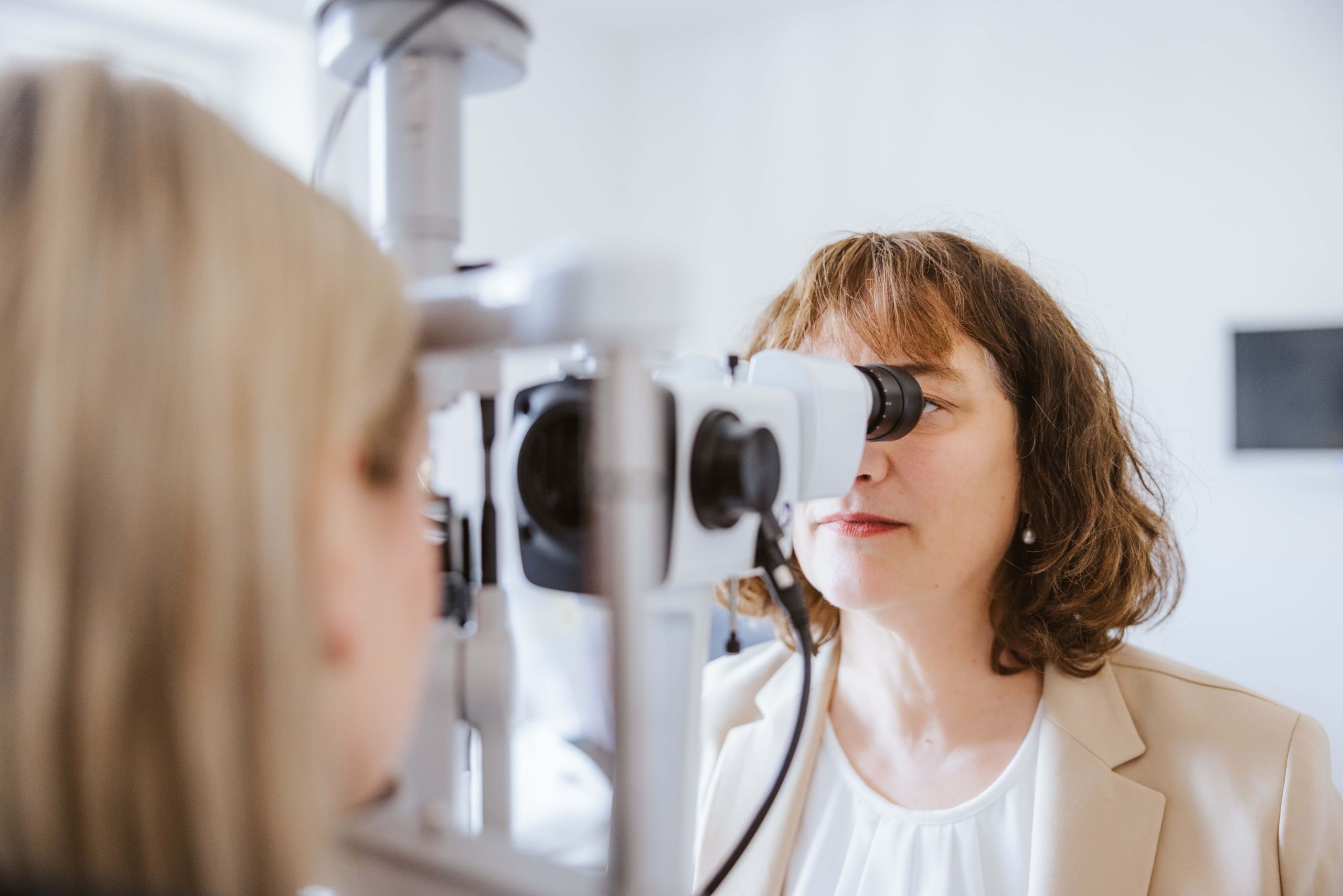 Dr. med. Ulrike Flach untersucht eine Patientin mit der Spaltlampe